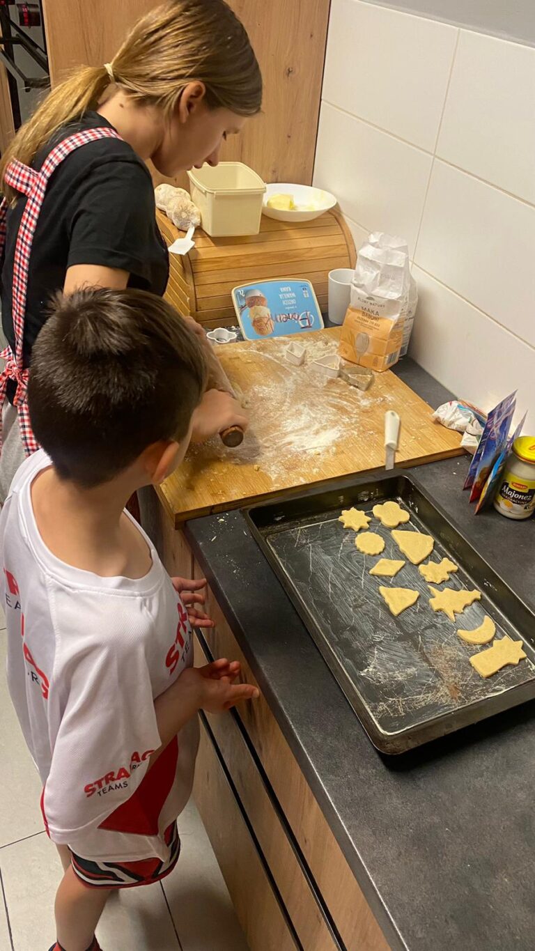 Chłopiec i dziewczynka przygotowują świąteczne pierniki w kuchni.
