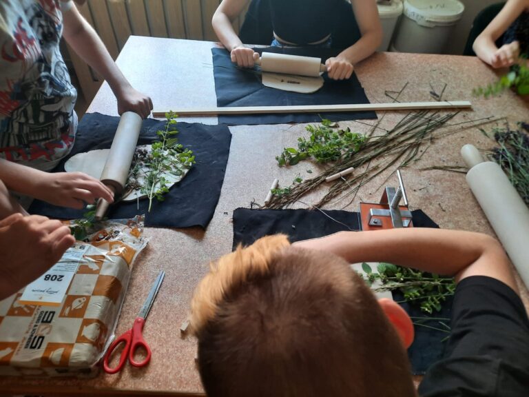 Dzieci podczas zajęć wykonują prace z gliny.