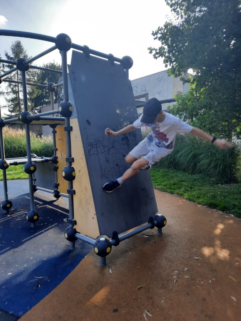 Chłopiec bawiący się na placu zabaw.