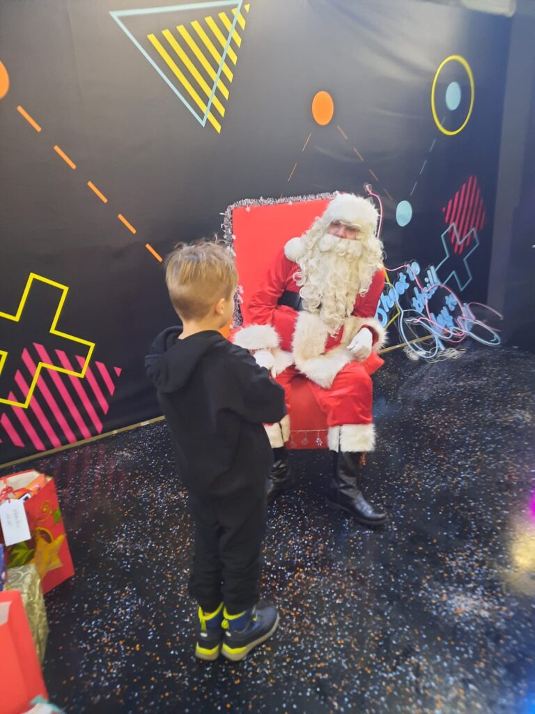 Chłopiec odbierający prezent od Świątego Mikołaja.
