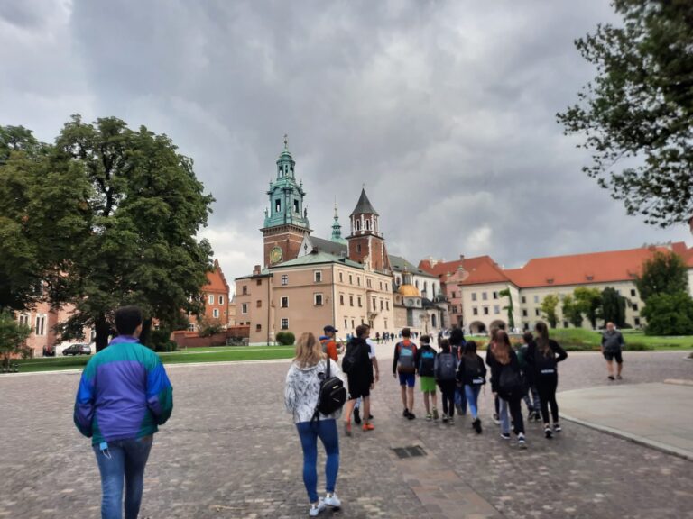 Wychowankowie podczas wycieczki do Krakowa spacerują w okolicach Wawelu.