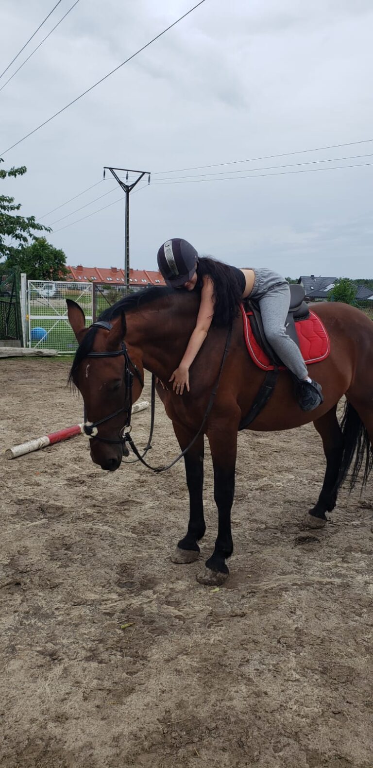 Wychowanka na grzbiecie konia wykonuje ćwiczenia.