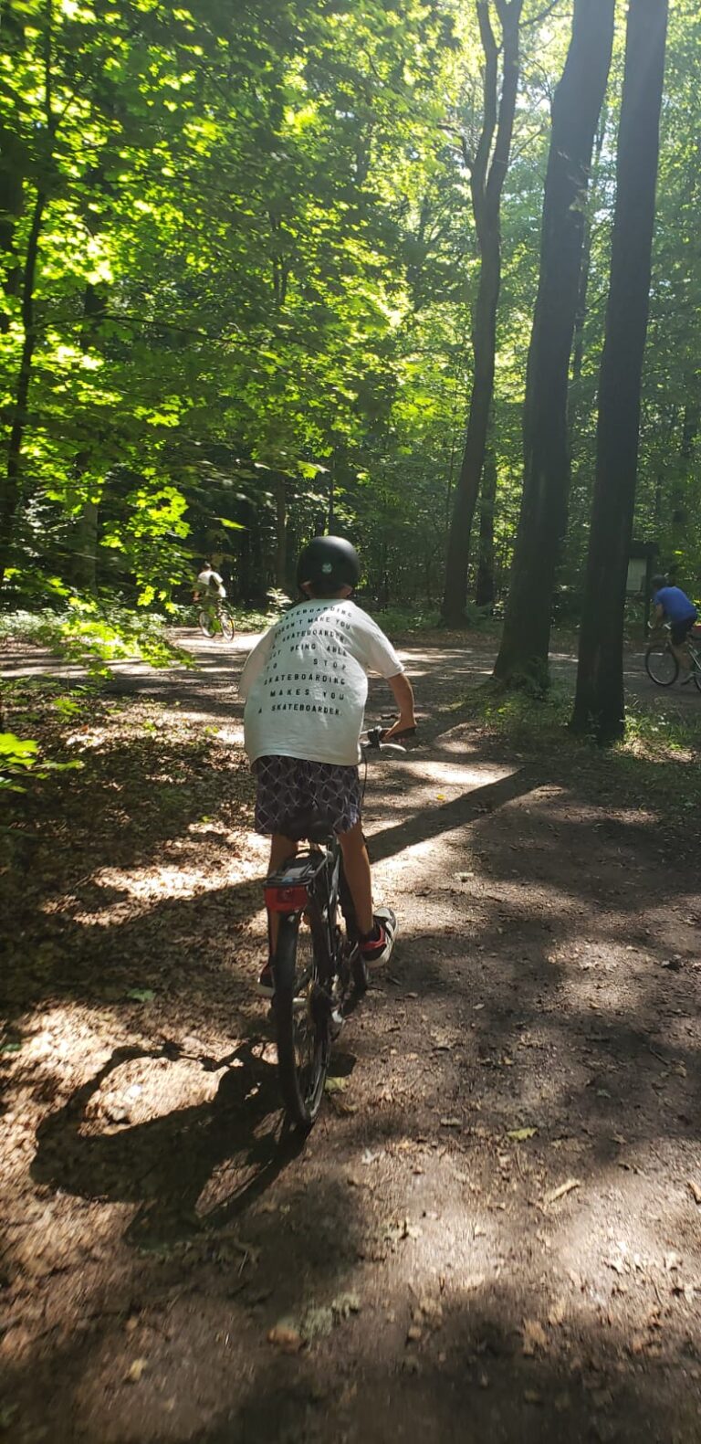 Wychowanek jedzie na rowerze podczas zorganizowanej wycieczki.